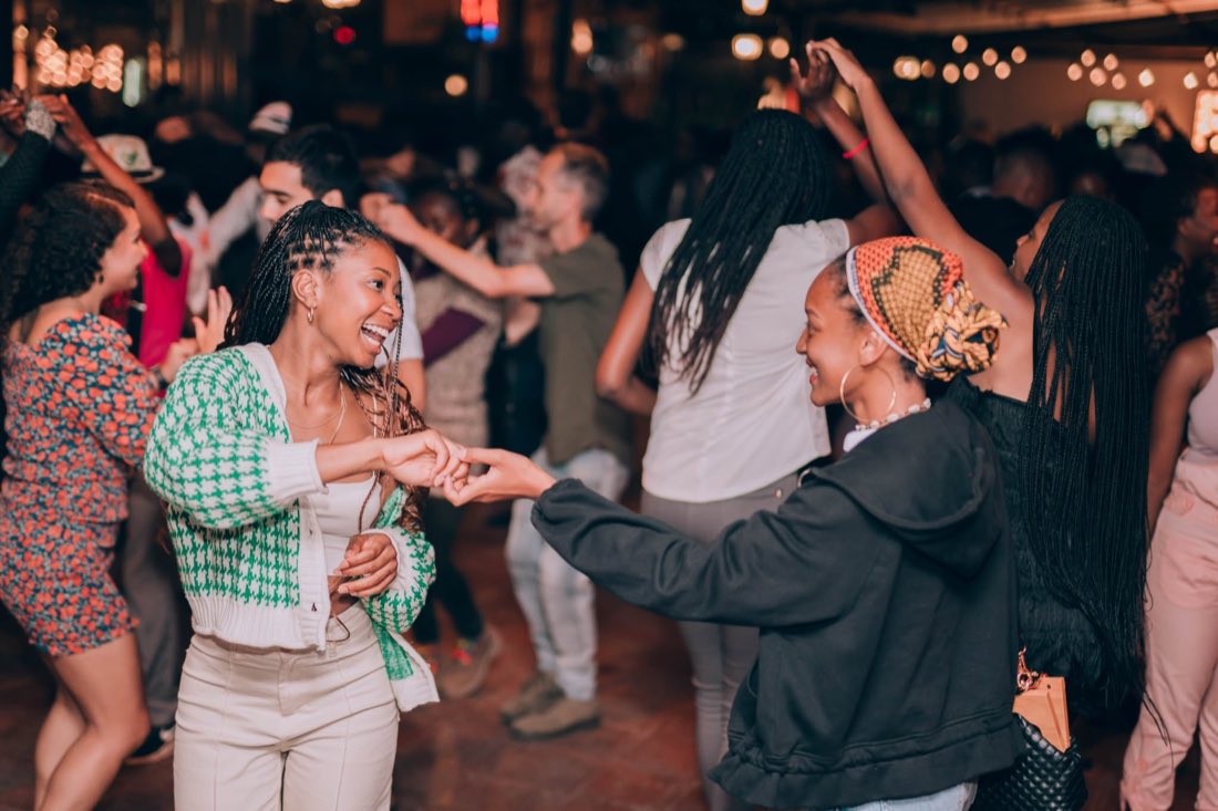 Two people dancing and laughing on a busy dance floor