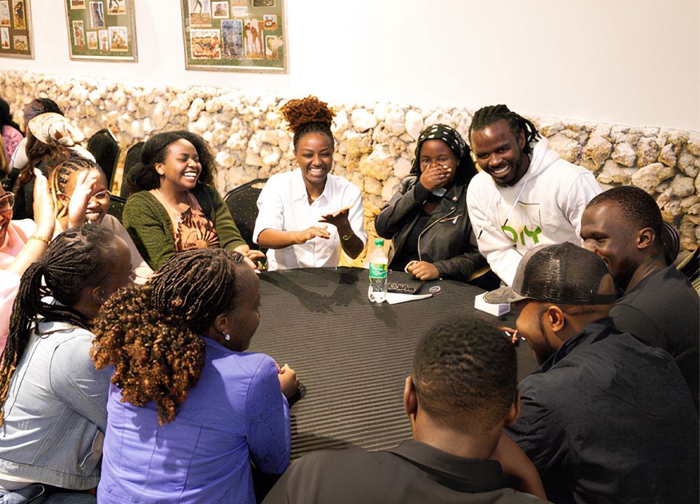 A group of guests laughing together around a table at a Social Tribe community event